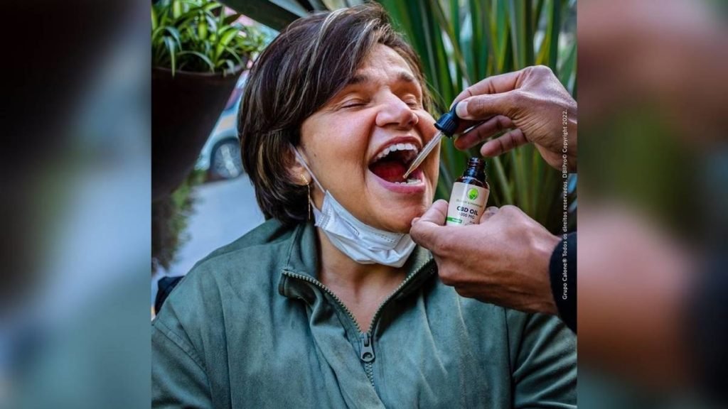 Foto colorida Claudia Rodrigues tomando canabidiol