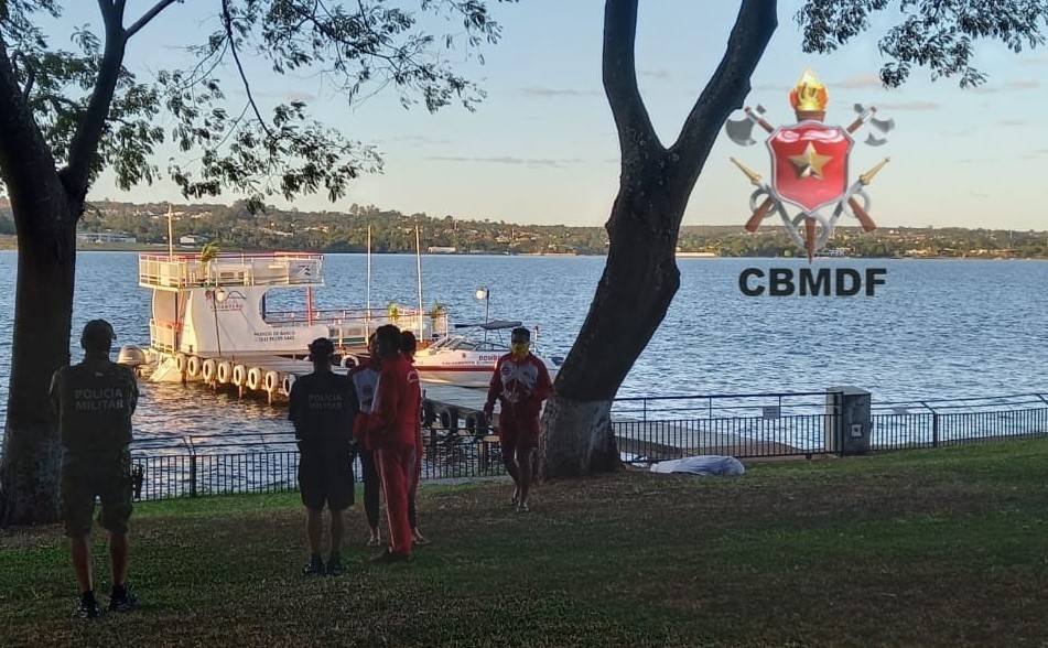 foto colorida de homens às margens do lago paranoá