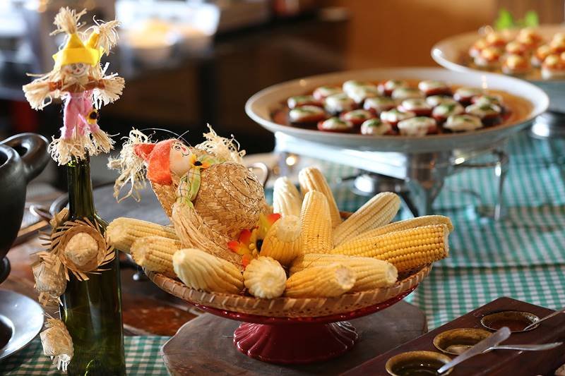 Bufêjunino do Gran Bier, com um prato cheio de espigas de milho em meio às decorações típicas da festa - Metrópoles