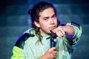 O comediante Whindersson Nunes durante show. Ele aponta para frente, com celular numa mão, e um microfone na outra - Metrópoles