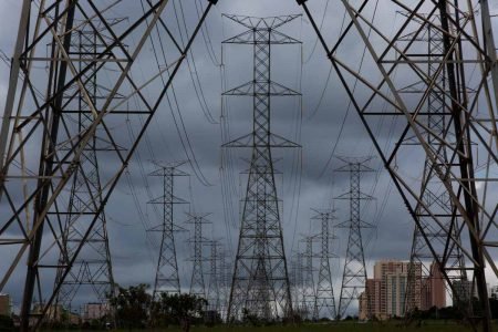 Linhas de transmissão de energia em horizonte com cidade ao fundo - Metrópoles