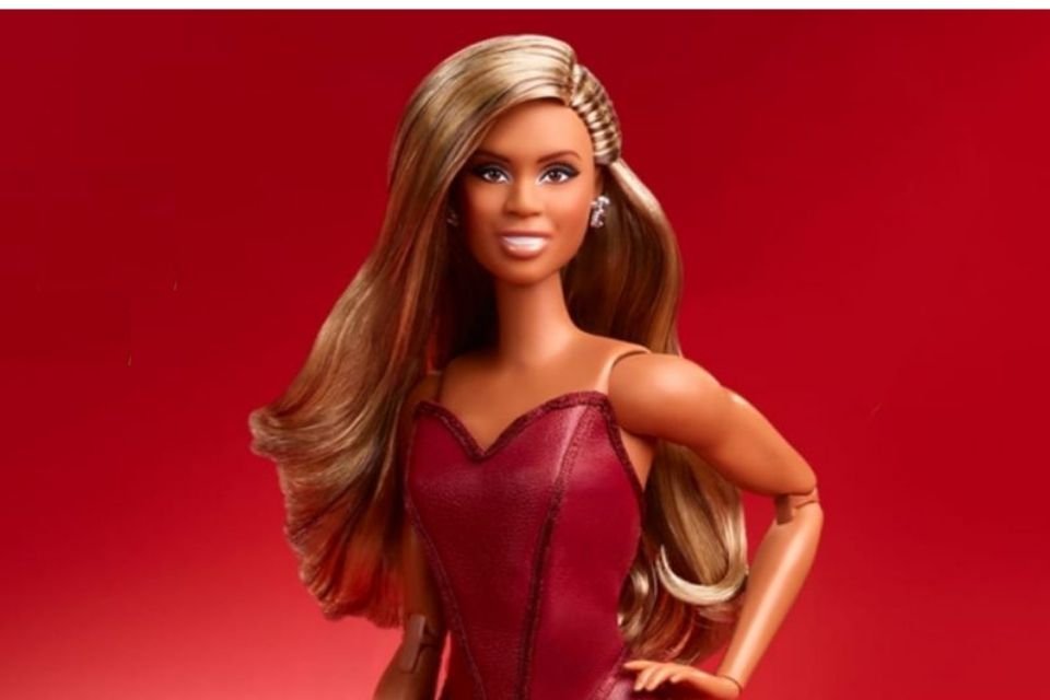 Primeira Barbie transsexual inspirada na atriz Laverne Cox. Ela é morena, tem cabelo dourado escuro, usa vestido vermelho e sorri - Metrópoles