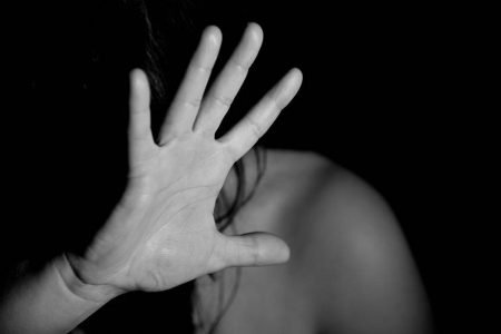 foto em preto e branco de mulher com a mão aberta protegendo o rosto