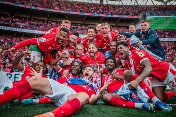 Imagem colorida jogadores do Forest comemorando o retorno a Premier League