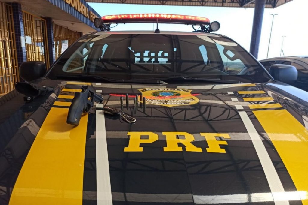 Revólver calibre 38 em cima de capô de viatura da PRF