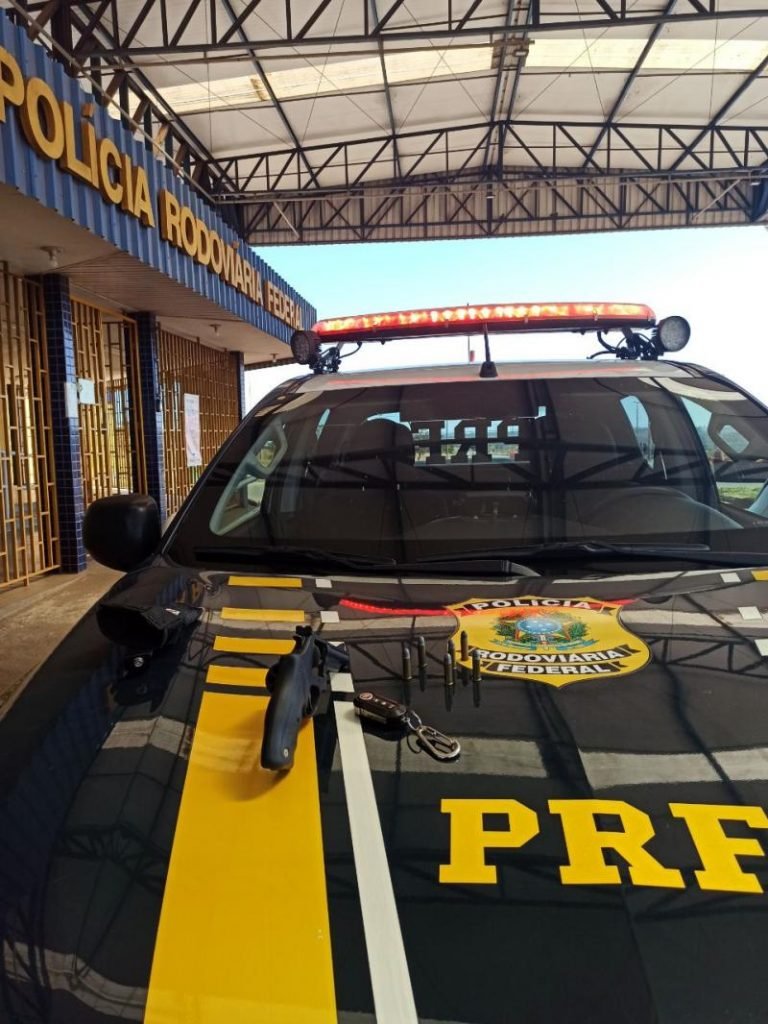Revólver calibre 38 em cima de capô de viatura da PRF