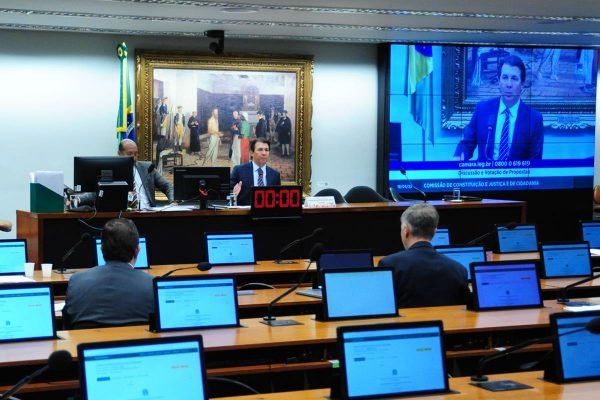 Sala da Comissão de Constituição e Justiça da Câmara dos Deputados com alguns deputados em bancadas frente aos monitores e mesa diretora - Metrópoles