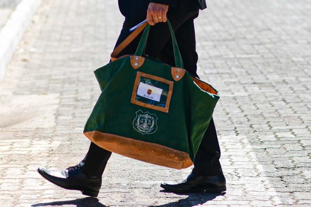 mão segurando uma bolsa verde