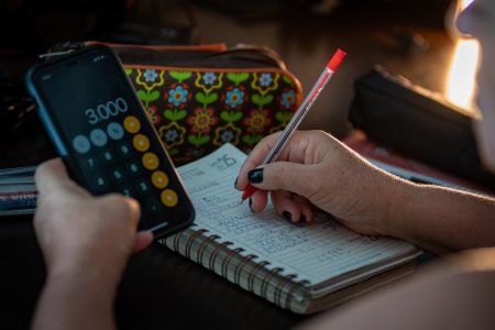 Mulher com calculadora faz contas do mês