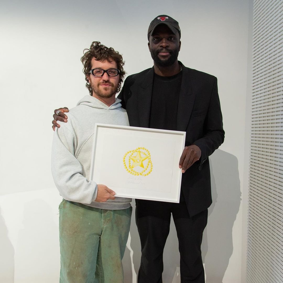 Na imagem com cor, dois homens aparecem segurando uma placa