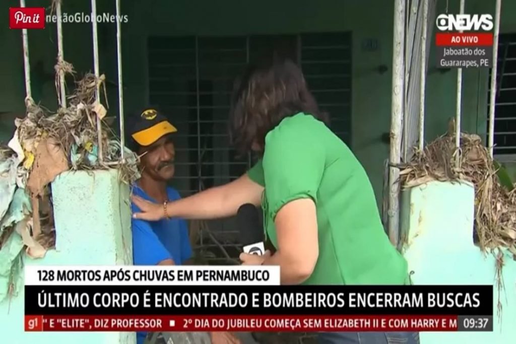 Foto colorida de repórter e entrevistado vítima de enchentes