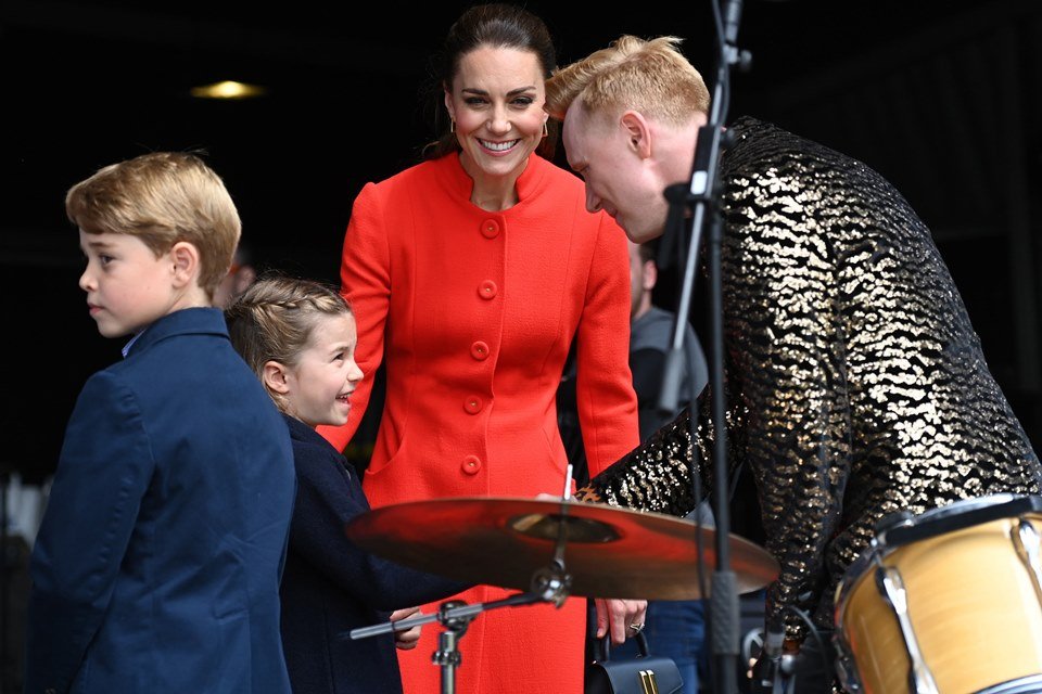 Foto colorida. Príncipe George e princesa Charlotte com Kate Middleton