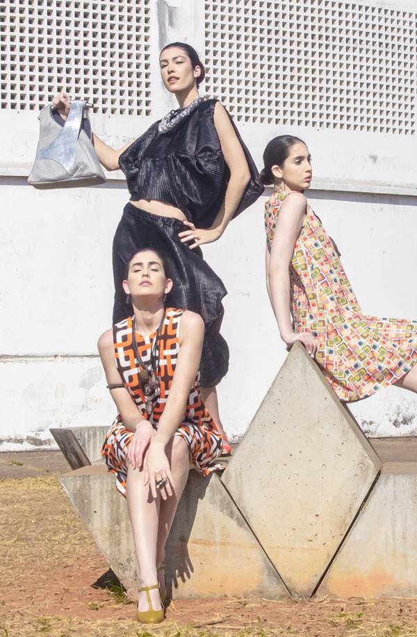 Três modelos com vestidos posando para foto