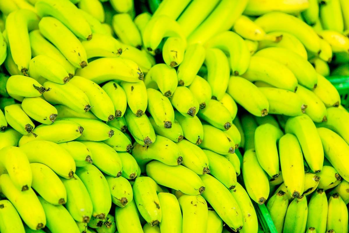 imagem colorida de bananas verdes em prateleira de supermercado
