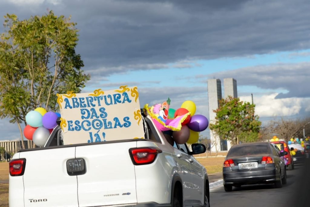 Carreata de professores e alunos de escola infantil a favor de volta as aulas presenciais.