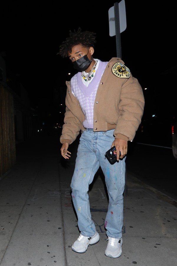O ator e cantor Jaden Smith, filho de Will Smith, andando pelas ruas de Los Angeles. Ele veste uma camiseta branca, colete de tricô lilás e branco, uma jaqueta puffer bege, calça jeans, tênis branco e uma máscara cirurgica para proteção contra o coronavírus.