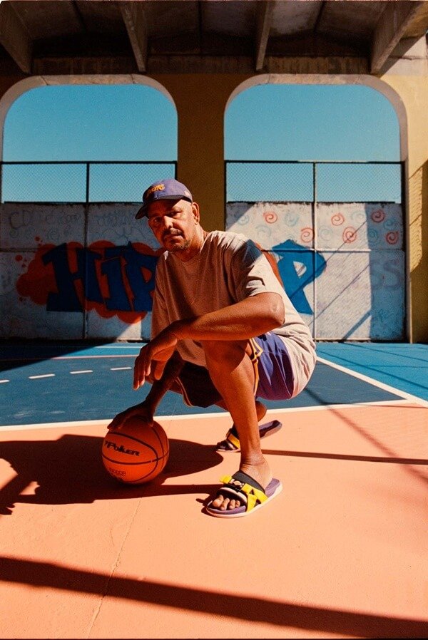 Na imagem com cor, homem usa chinelo da Rider na quadra de basquete