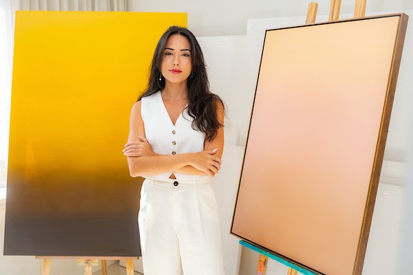mulher sentada em sala com quadros ao fundo