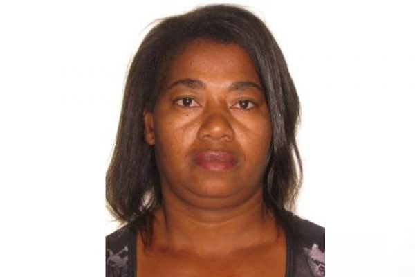 Mulher negra com cabelo liso curto e rosto sério em frente a fundo branco