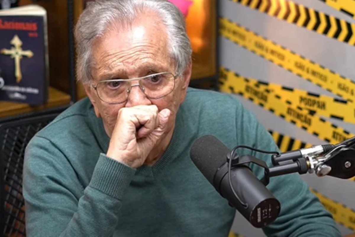 Foto colorida de Carlos Alberto de Nóbrega com a mão em frente ao rosto e falando em microfone no PodPah - Metrópoles