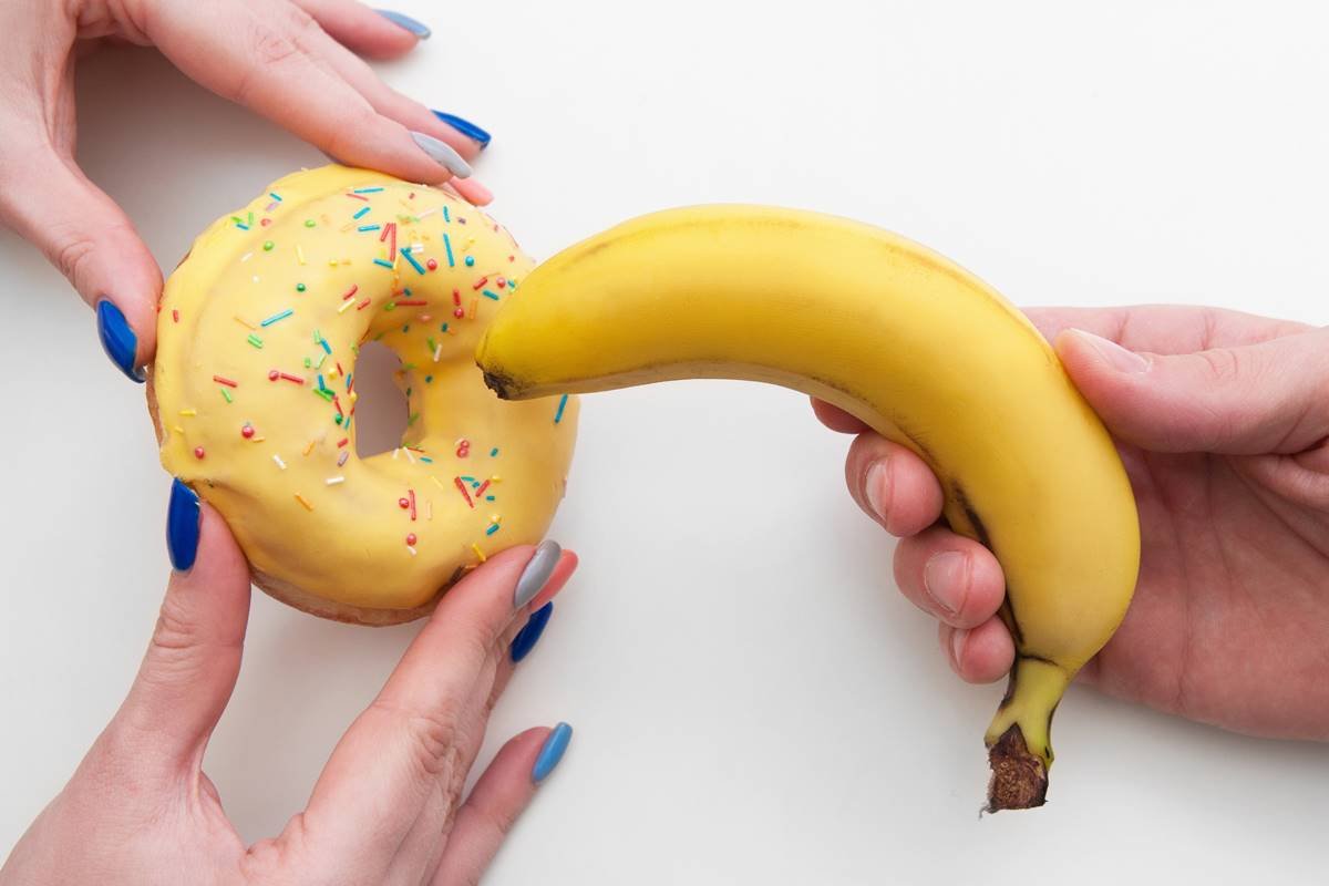 Foto de um donuts amarelo e uma banana lado a lado, simulando a prática do sexo anal