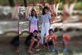 Duas meninas em pé e dois meninos abaixados em parquinho