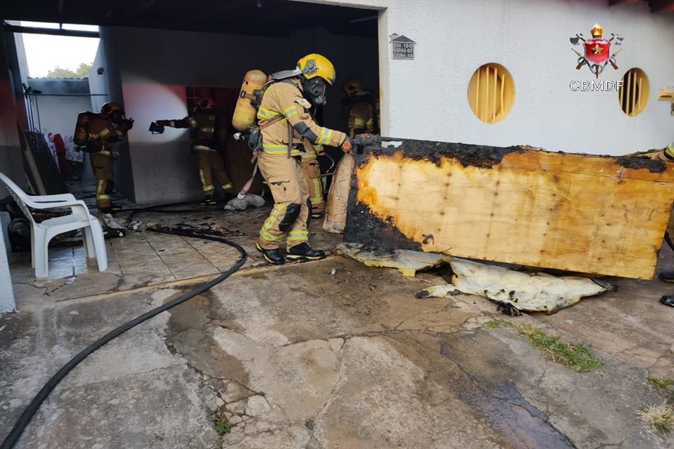 bombeiro retirando cama queimada de casa que pegou fogo
