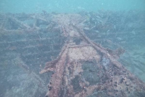 foto colorida de destroços de avião embaixo d'água