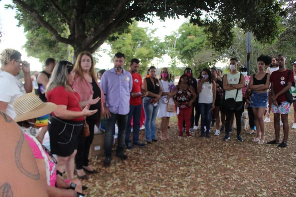 Pessoas reunidas em roda debaixo de árvore no parque