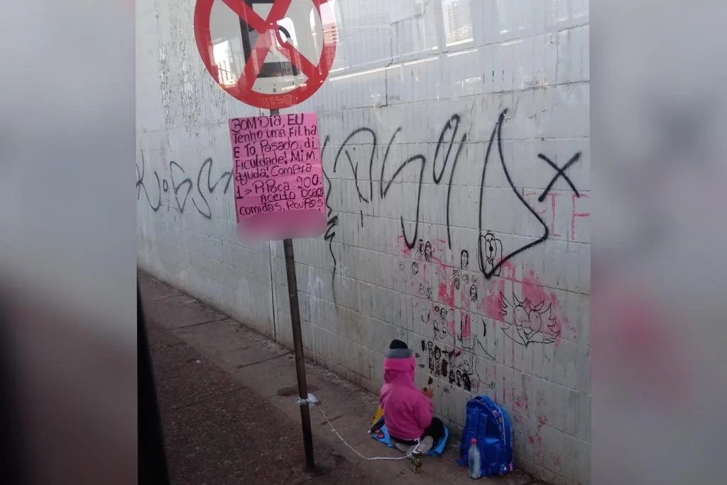 Menina amarrada a uma placa de sinalização