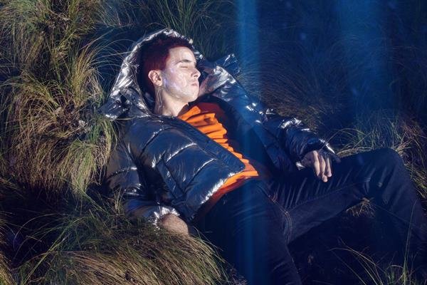 Caucasian man in metal clothes lying on the lawn