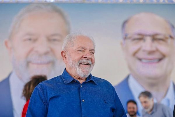 O ex-presidente Lula em frente a mural de campanha com a foto de Geraldo Alckmin