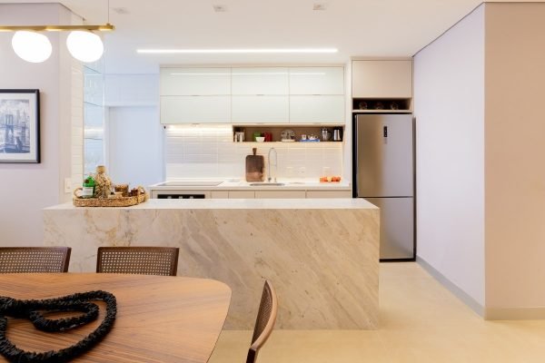 Imagem colorida da cozinha integrada a asala de jantar