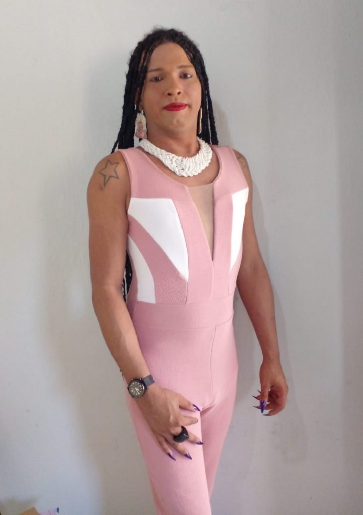Lana com macacão rosa e trança no cabelo