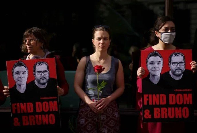 Mulheres segurando rosas e um cartaz pedindo para encontrar Dom e Bruno, que estavam desaparecidos na Amazônia - Metrópoles
