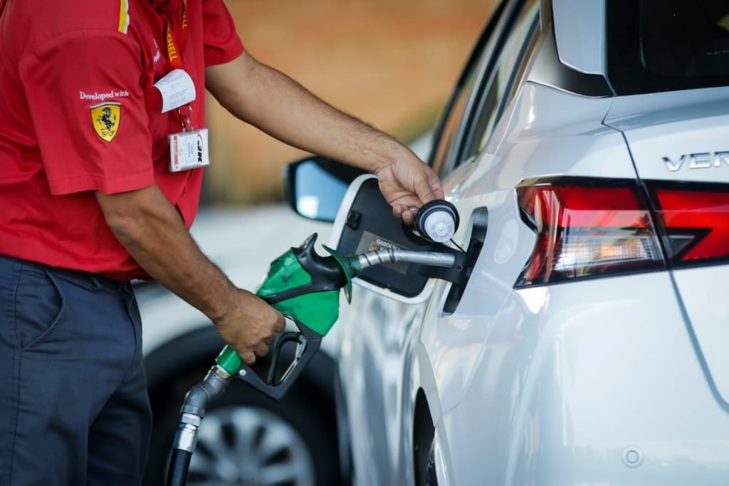 frentista do posto shell abastece veículo com gasolina