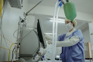 Imagem mostra servidora da saúde manuseando um equipamento em Anápolis (GO)