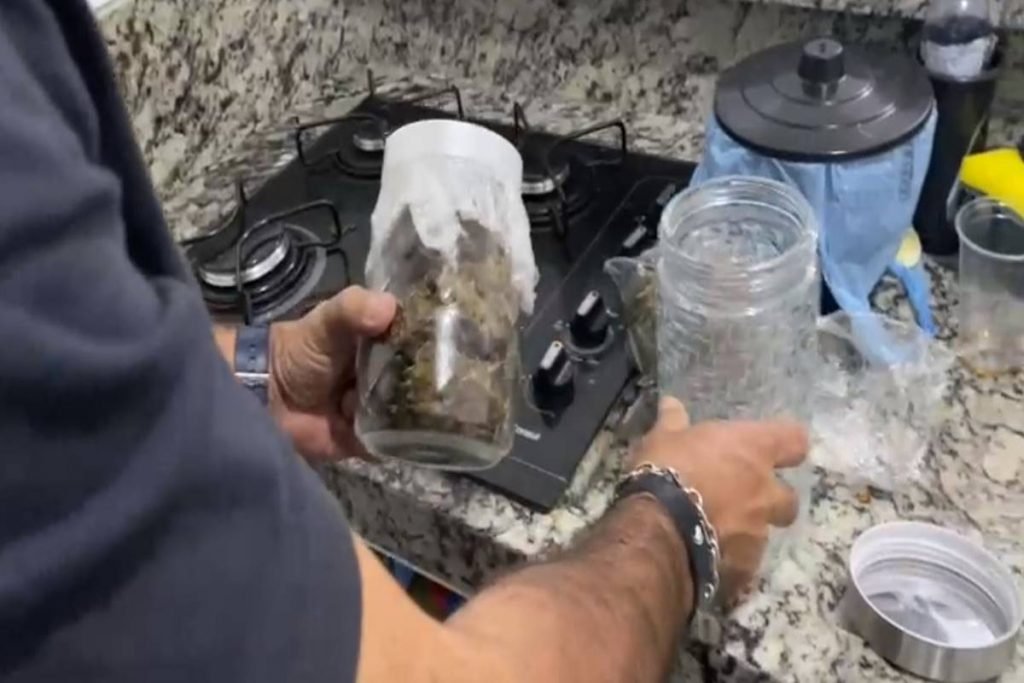 Homem segura potes de vidro com maconha - Metrópoles