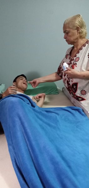 mulher cuida de rapaz na cama