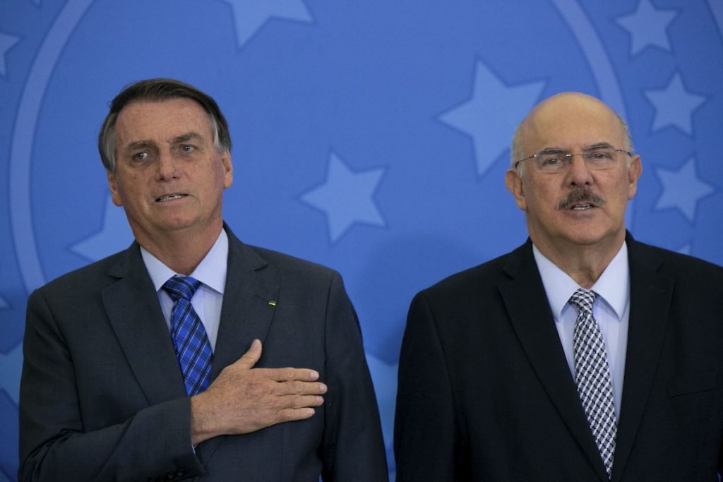 presidente jair bolsonaro com a mão no peito e ao lado ex ministro da educação Milton Ribeiro durante hino nacional