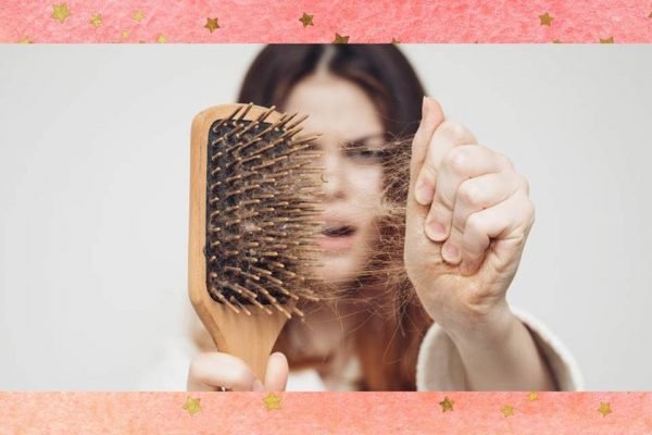 foto colorida de uma mulher tirando vários fios de cabelo de uma escova