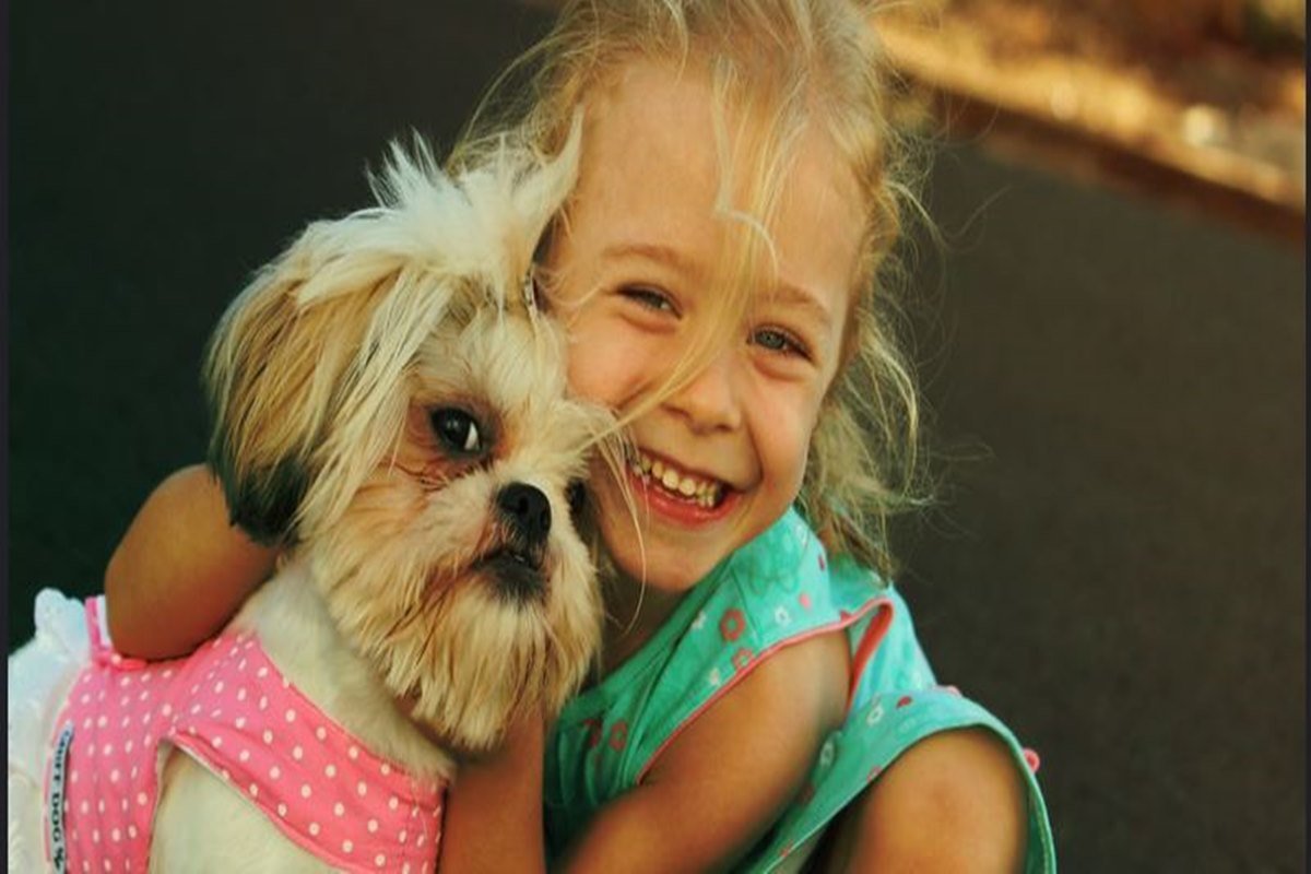 Imagem colorida de uma menina e um cachorro
