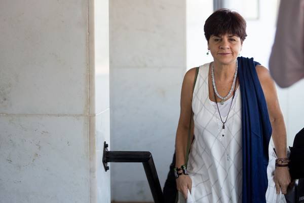 Fotografia colorida de mulher com vestido branco e lenço azul