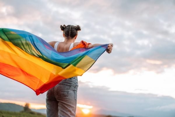 mulher segurando bandeira do orgulho LGBTQIAPN+