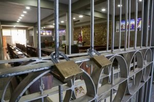 cadeados em grade de igreja. Objetos religiosos ao fundo