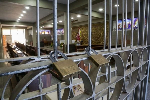 cadeados em grade de igreja. Objetos religiosos ao fundo