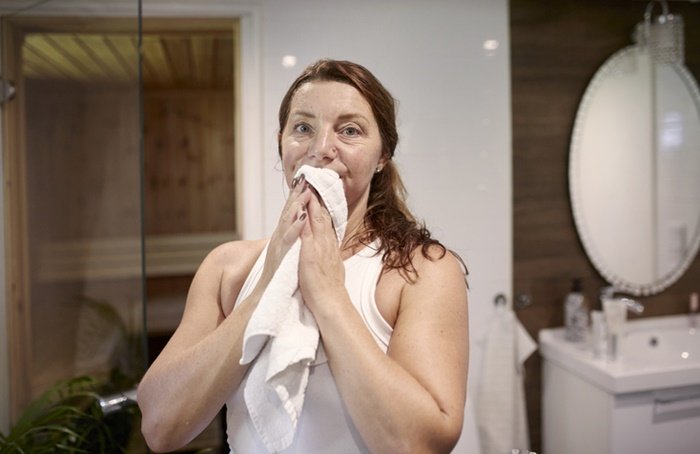 A woman drying her mouth with a towel - Metropolis