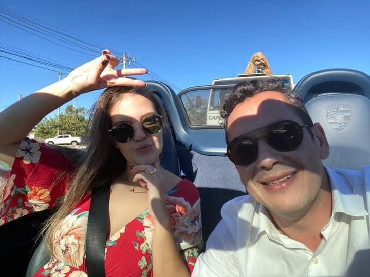 Casal dentro de Porsche com óculos escuro