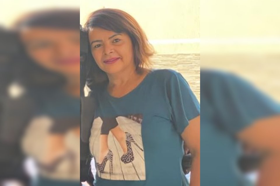 Mulher com cabelo curto e camisa azul com salto alto desenhado na blusa