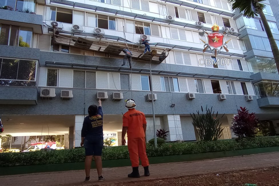 Foto de bombeiros em frente a um prédio